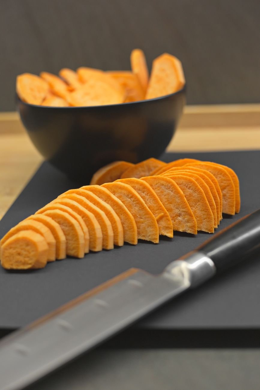 Cut sweet potatoes on a wooden board
