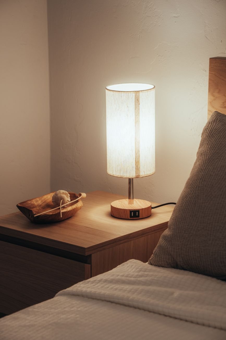 A simple nightstand with a lamp and a book