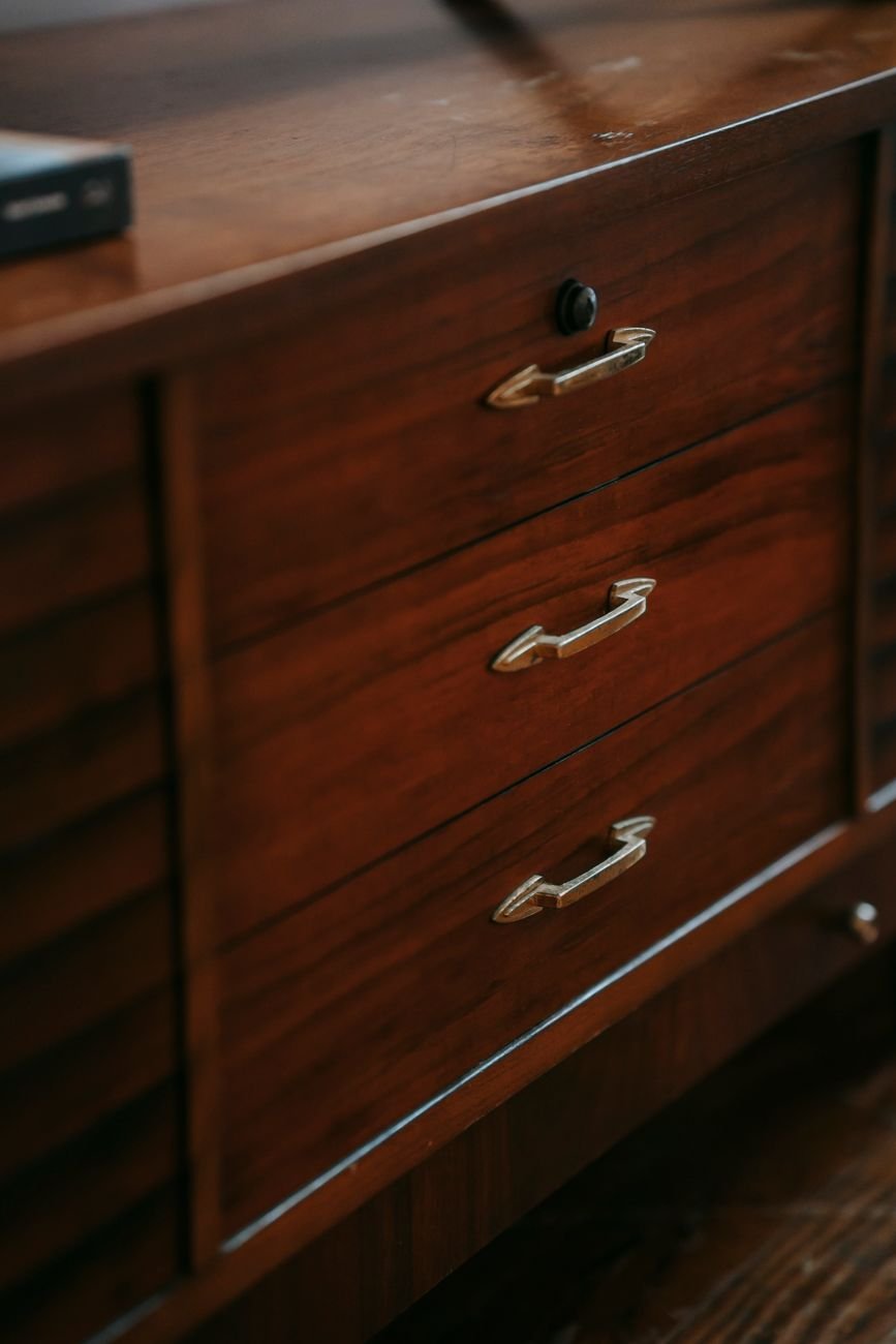 A wooden dresser with a few decor items on top