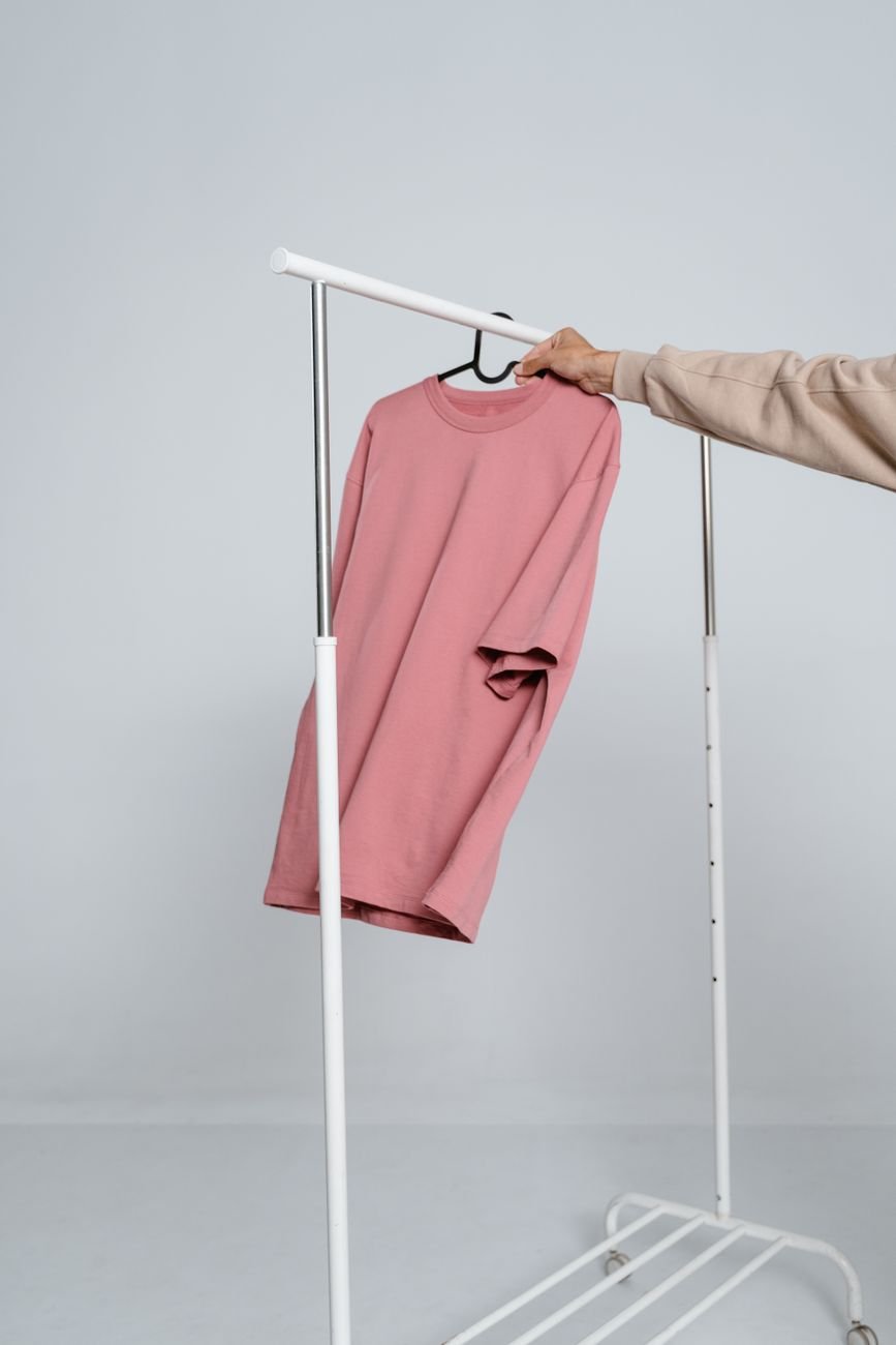 Clothes hanging neatly in a small wardrobe