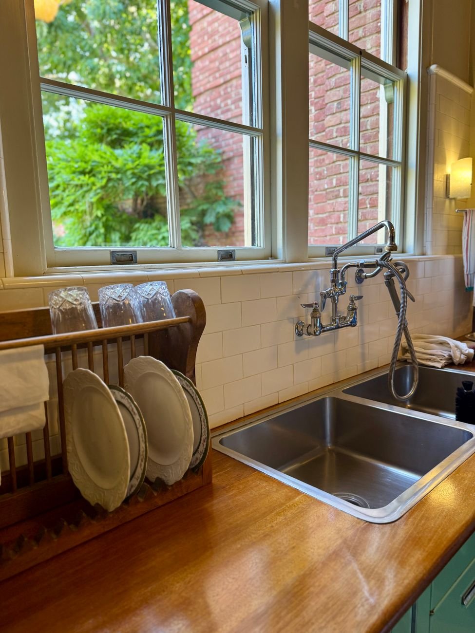 Dishes drying in a rack beside a clean kitchen sink