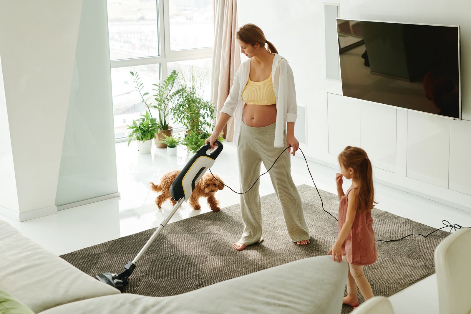 A mom tidying a bright living room after work