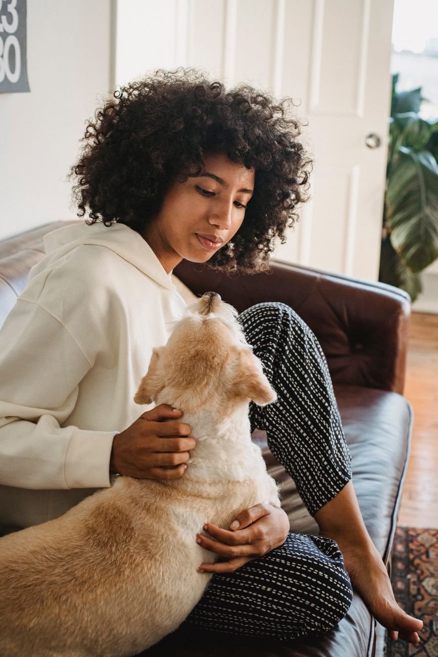 A mom relaxing on the couch with her dog