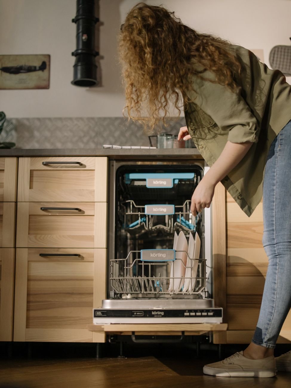 A person loading a dishwasher after dinner