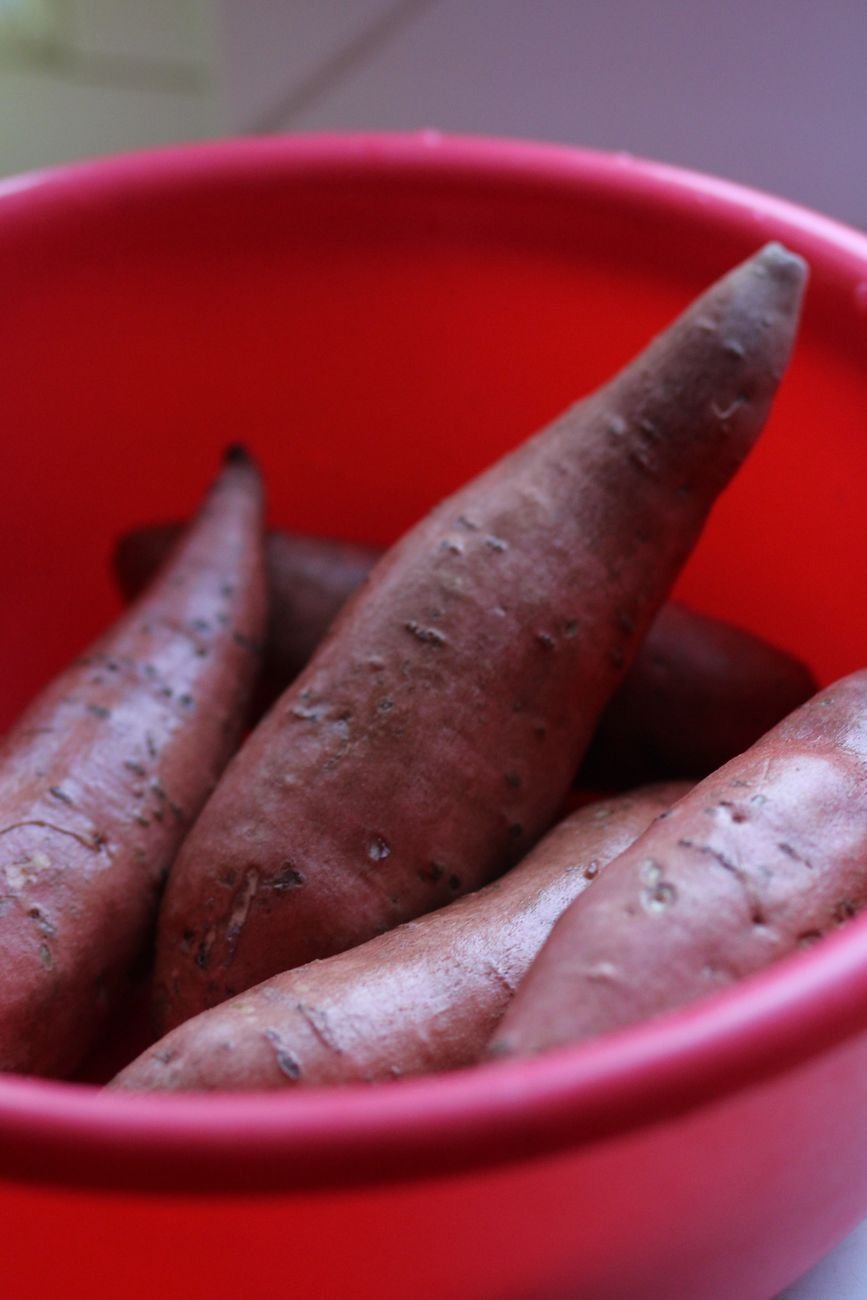 Whole raw sweet potatoes on a kitchen counter