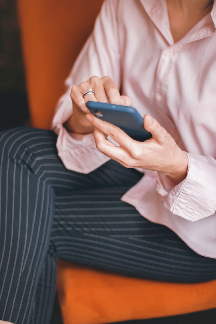 A person scrolling on a phone on the couch