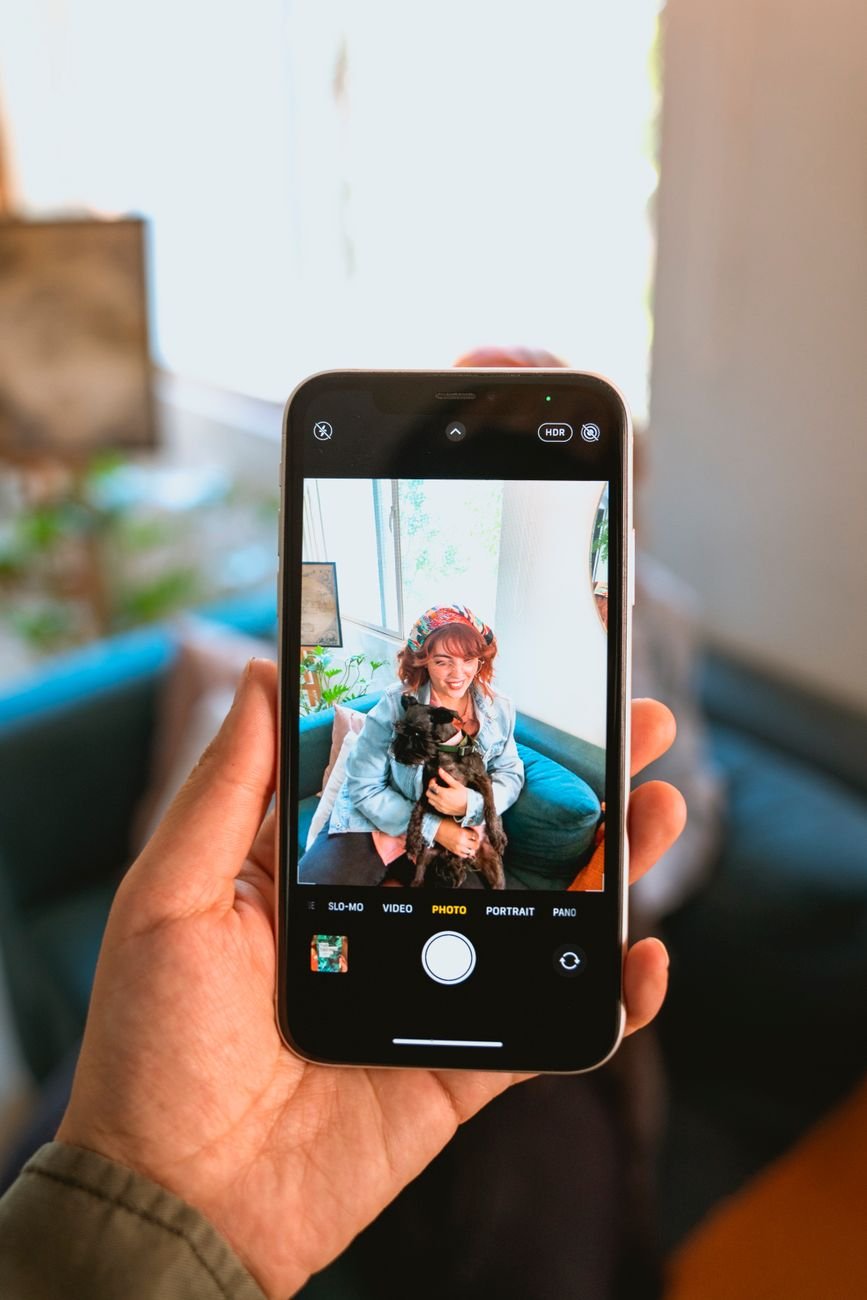 A person taking a photo of their dog with a phone