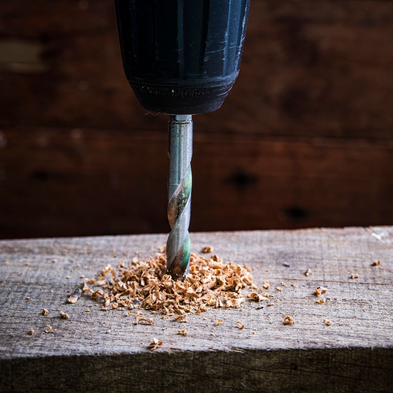 A person measuring wood with a tape measure
