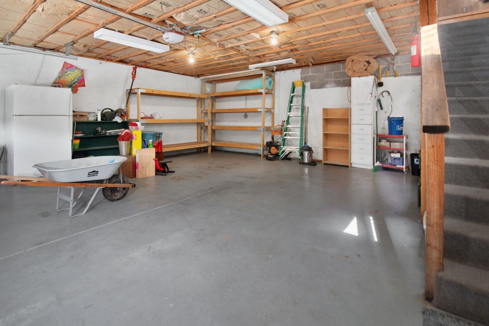 A tidy garage with shelves, storage bins and tools hung on the wall
