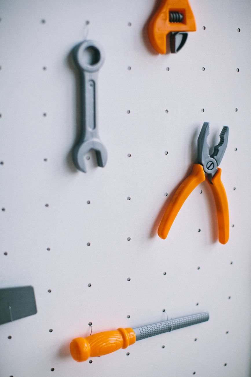 Hand tools hanging neatly on a pegboard wall