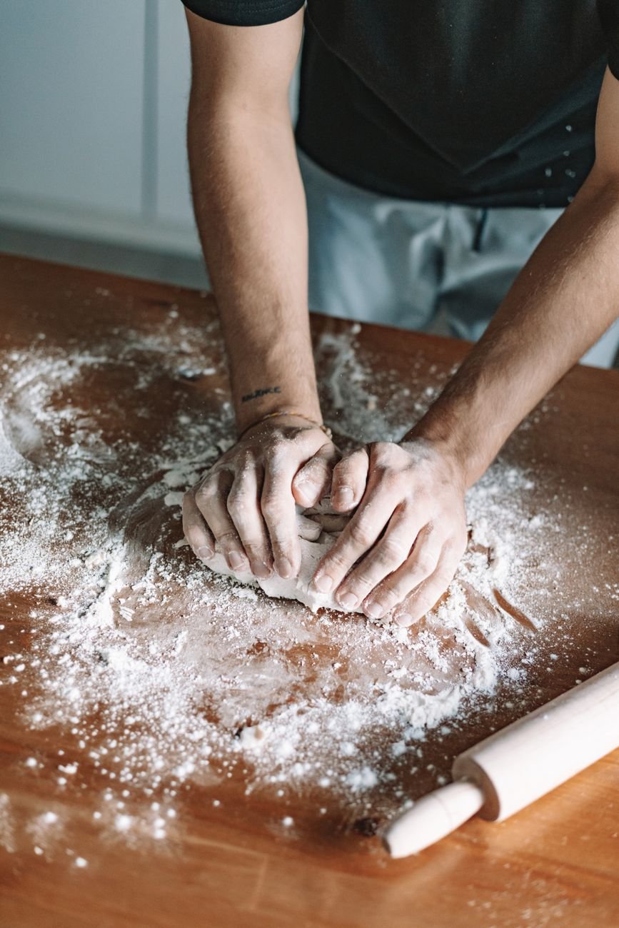 Dough being rolled out on a floured counter