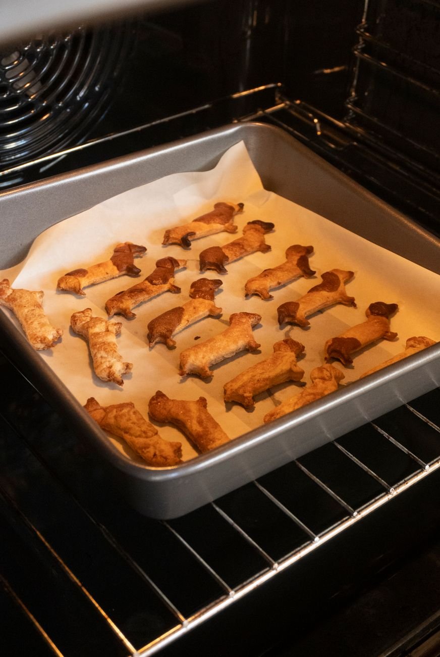 Homemade bone-shaped dog biscuits on a baking tray