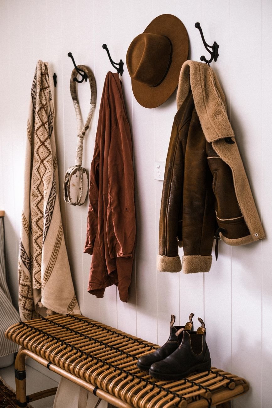 An entryway with a bench, hooks and a basket for shoes