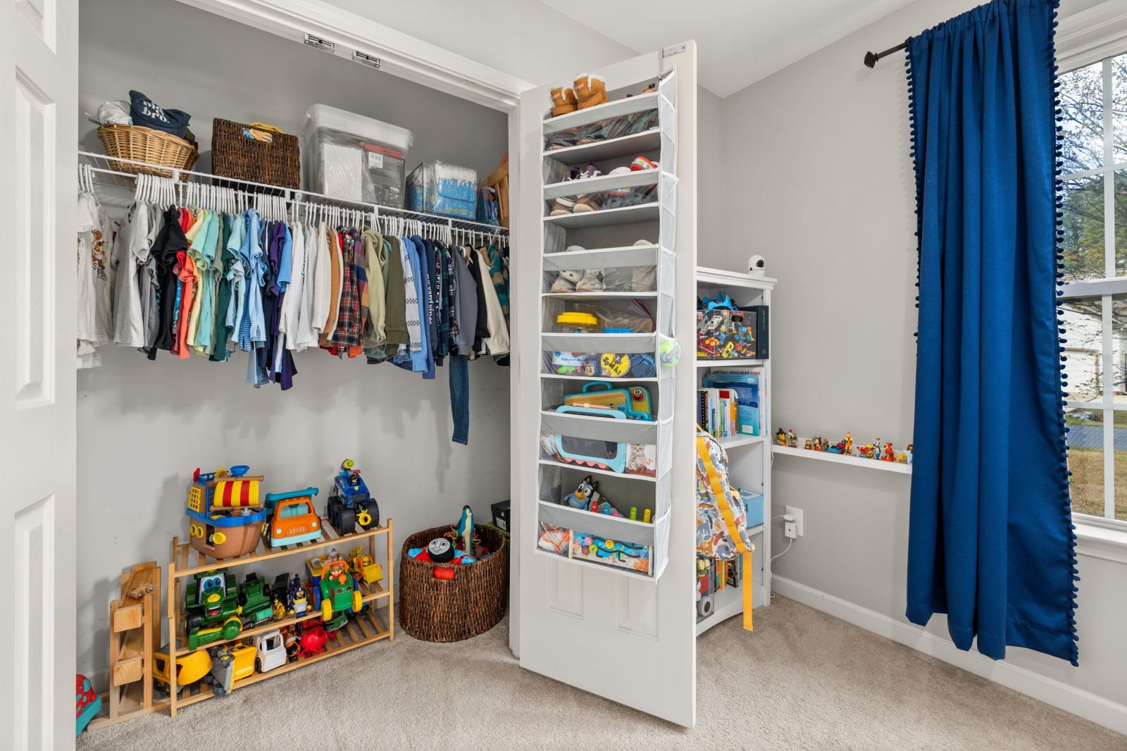 A tidy kids' room with low shelves, toy bins and a small play table