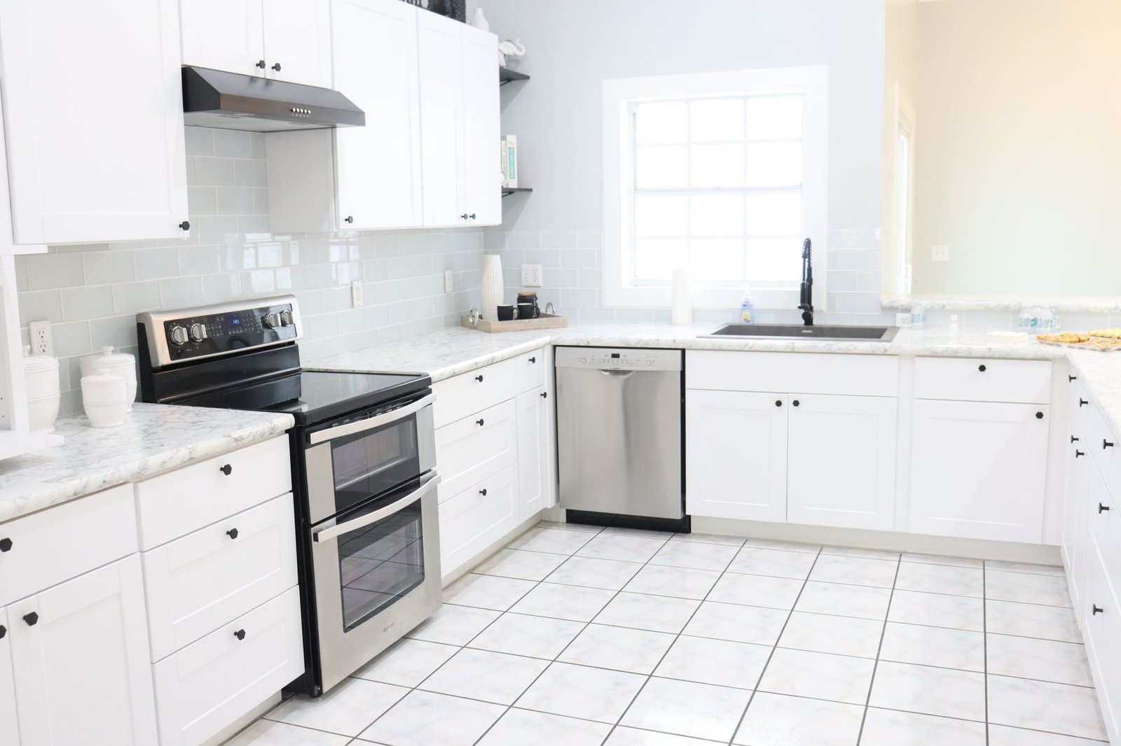 A bright, clean kitchen with clear countertops and a tidy sink