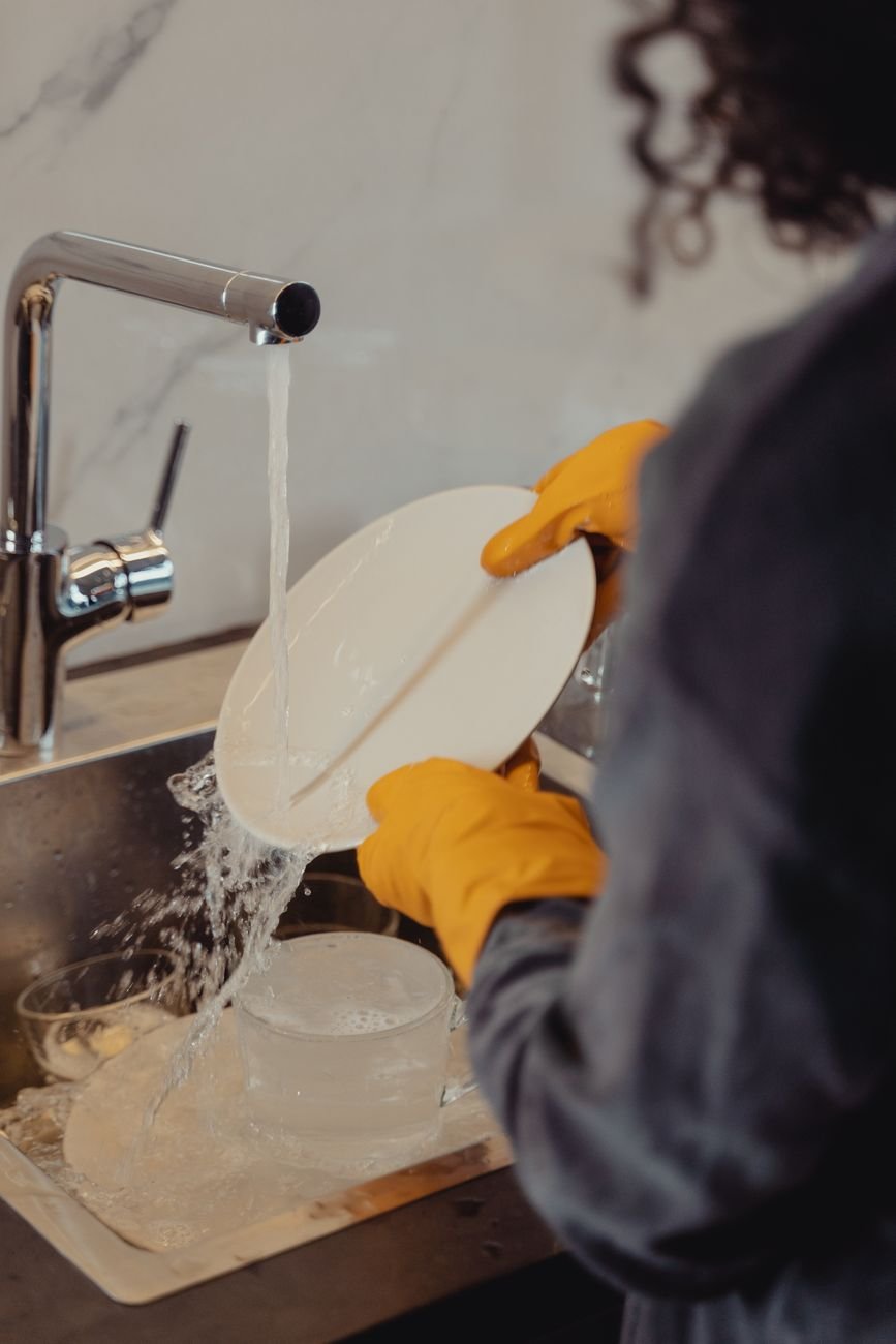 An open dishwasher loaded with clean plates