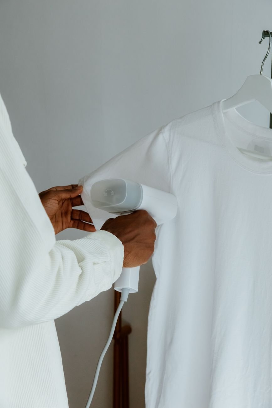 A hand treating a stain on a white shirt