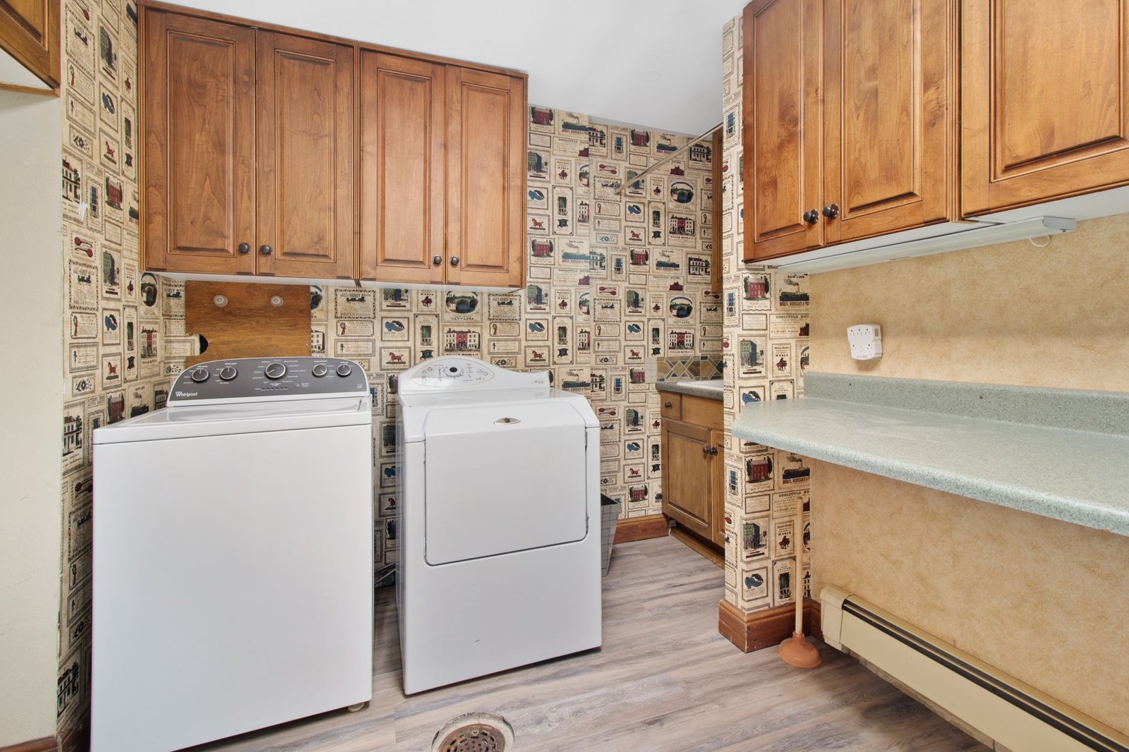 A bright, organized laundry room with a washer, dryer and shelves above