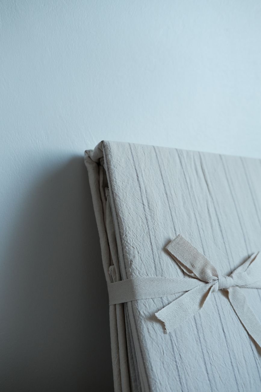 A stack of folded bed sheets in soft colors