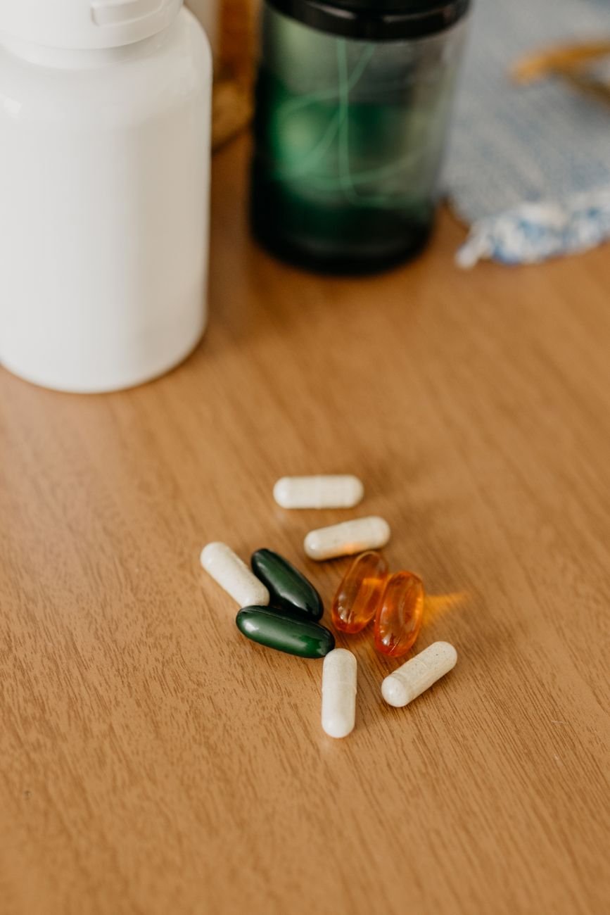 A cluttered pile of pill bottles and boxes on a counter
