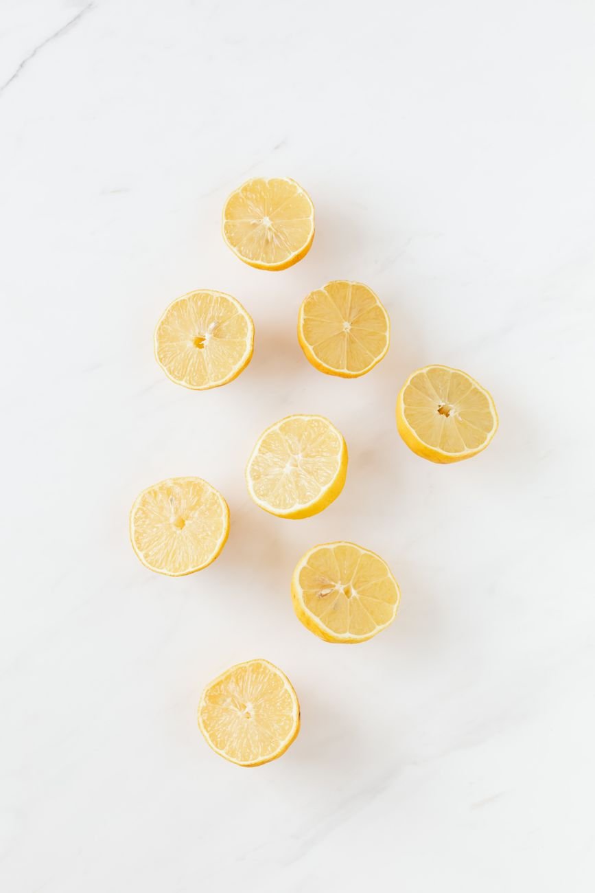 Fresh lemons cut in half on a kitchen board
