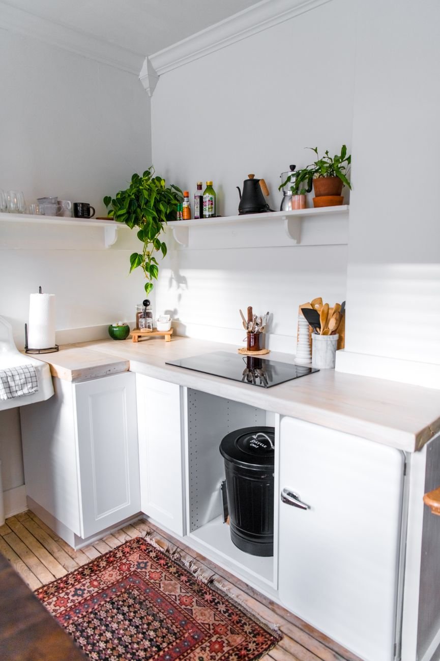 A tidy white kitchen with open shelves