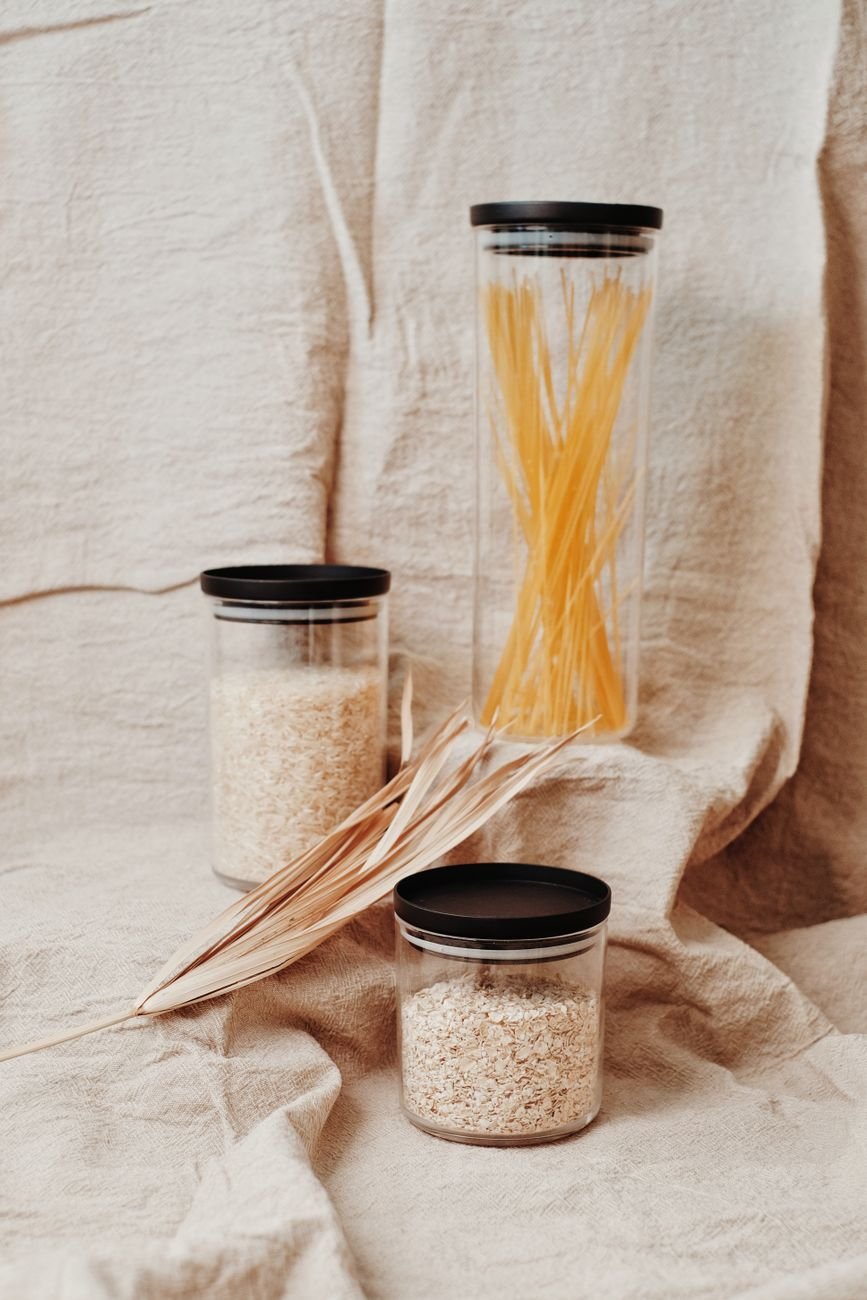 Glass jars of pasta, rice and beans on a pantry shelf