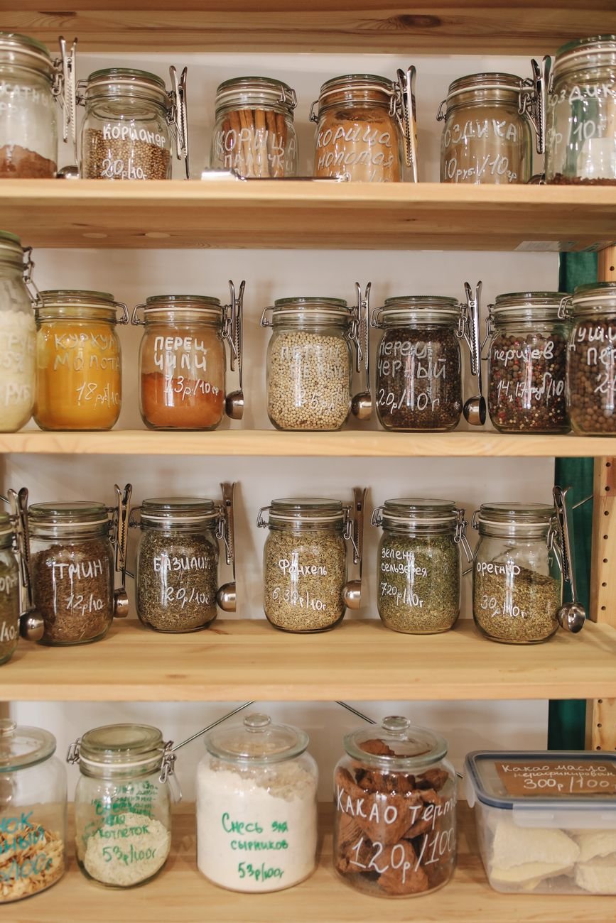 Glass jars of dry ingredients lined up on pantry shelves