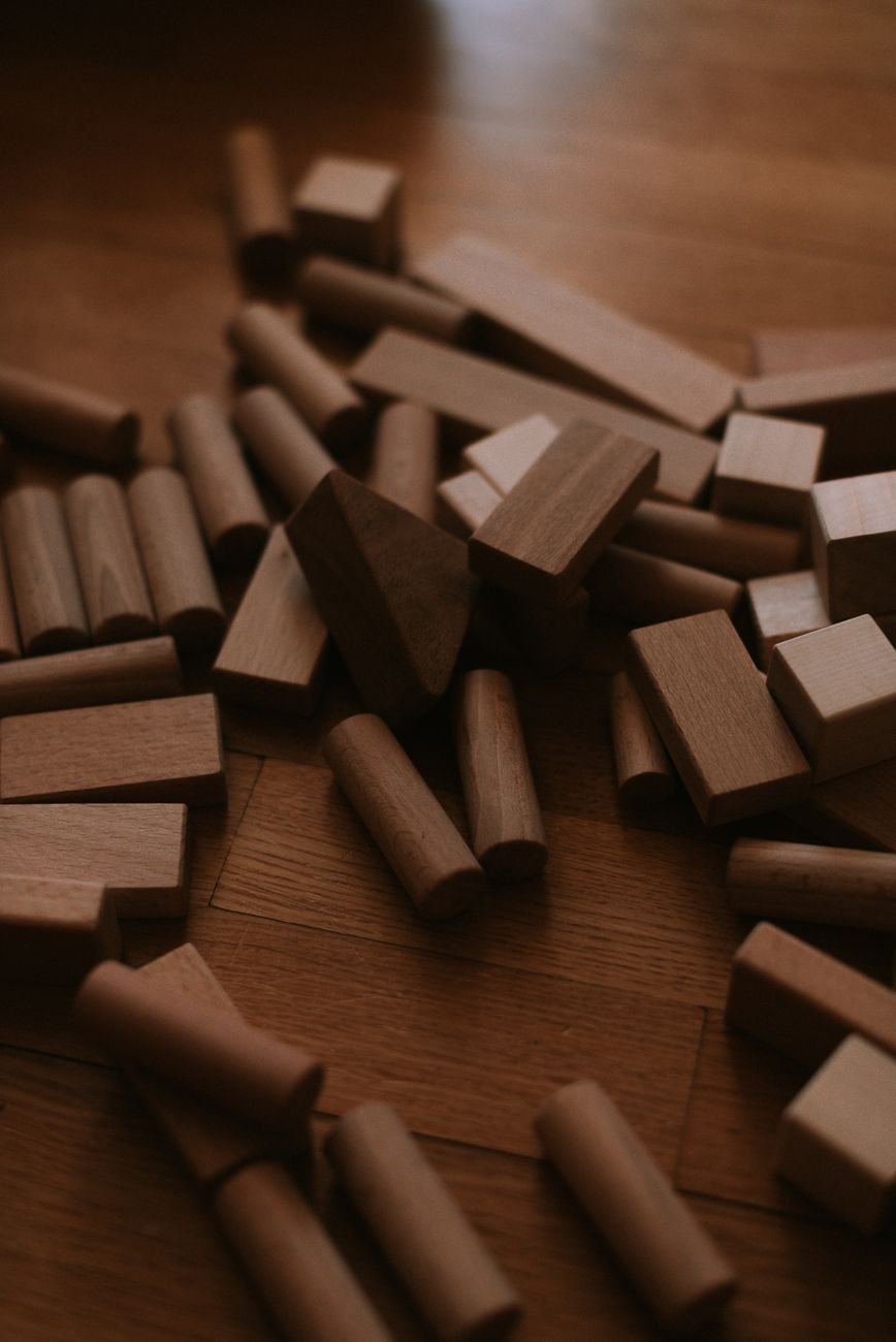 A toddler playing with wooden blocks on a rug
