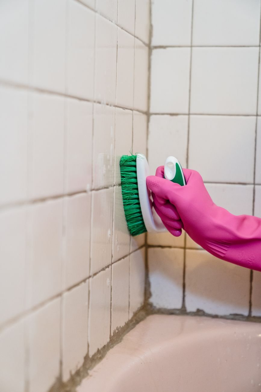 A brush scrubbing tile grout lines