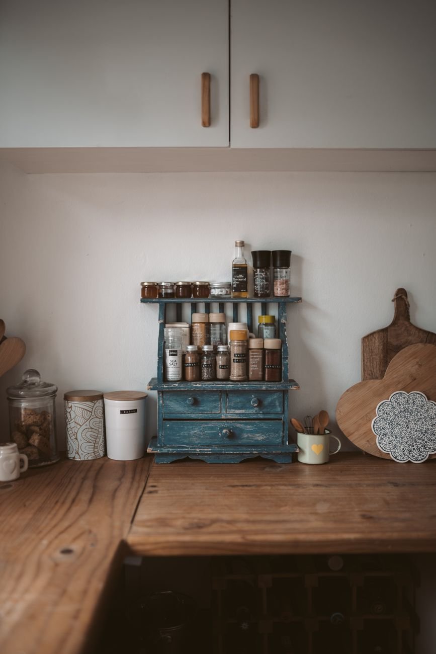 A pile of mixed spice jars and packets on a kitchen counter