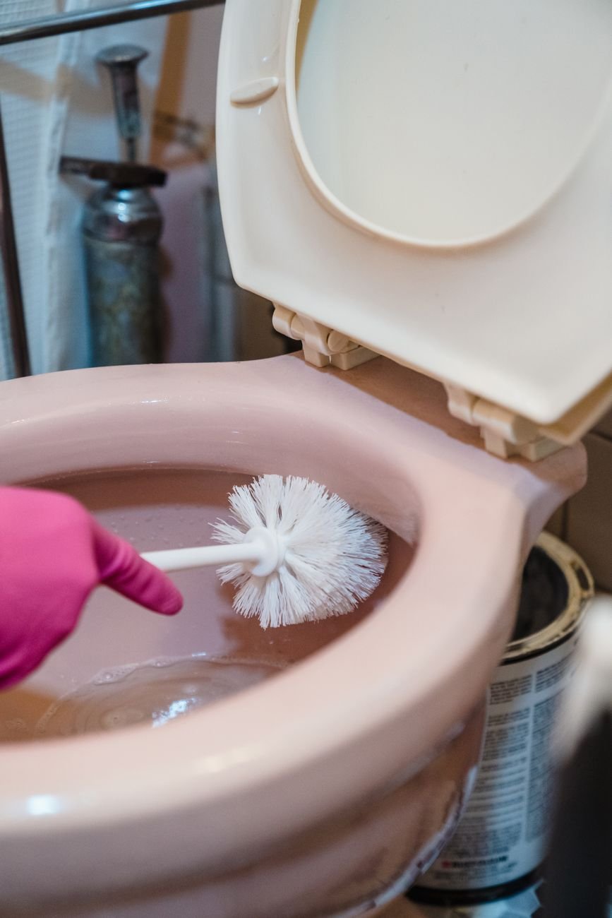 A toilet brush standing in a holder