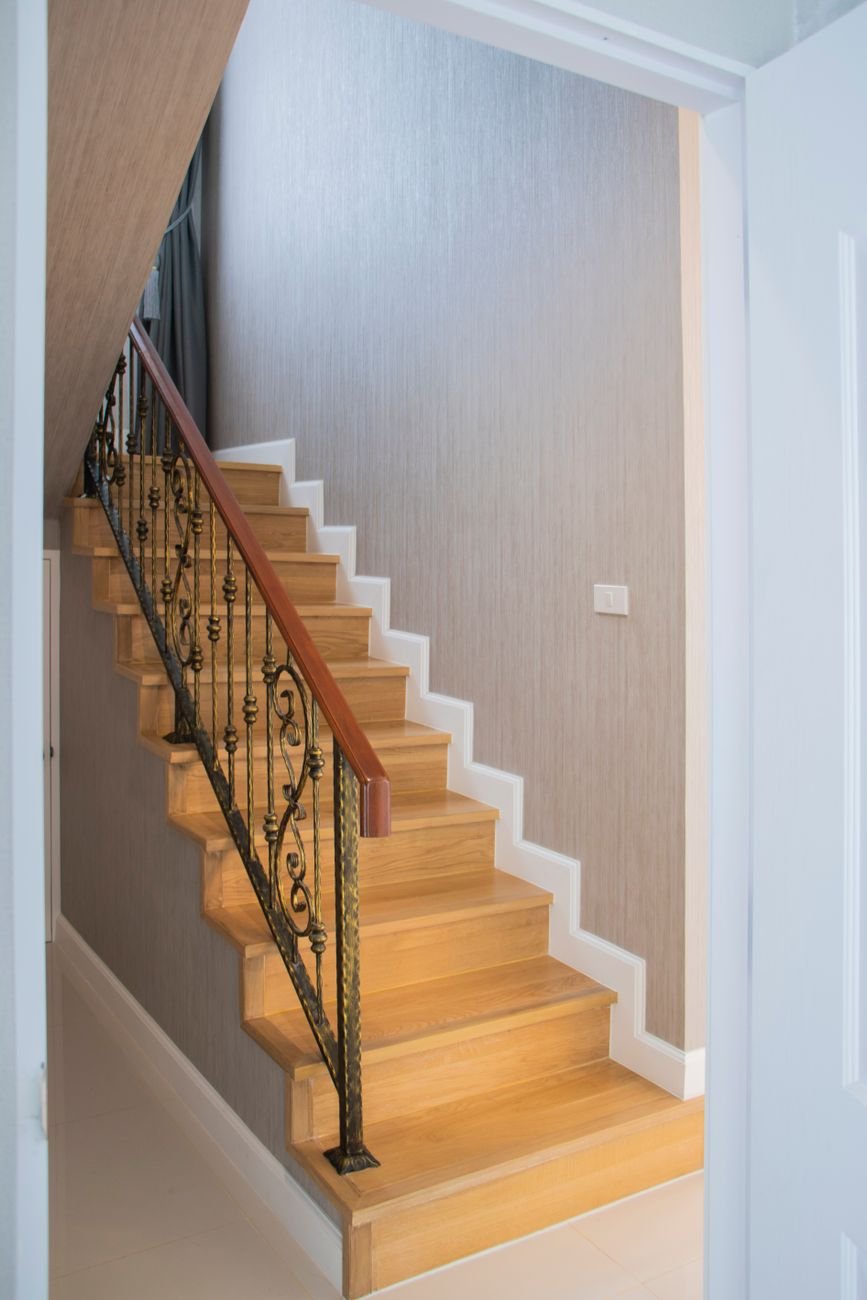 A wooden staircase in a bright home hallway