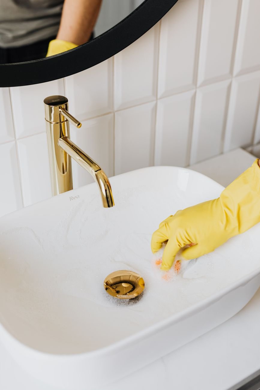A clean white bathroom sink and mirror