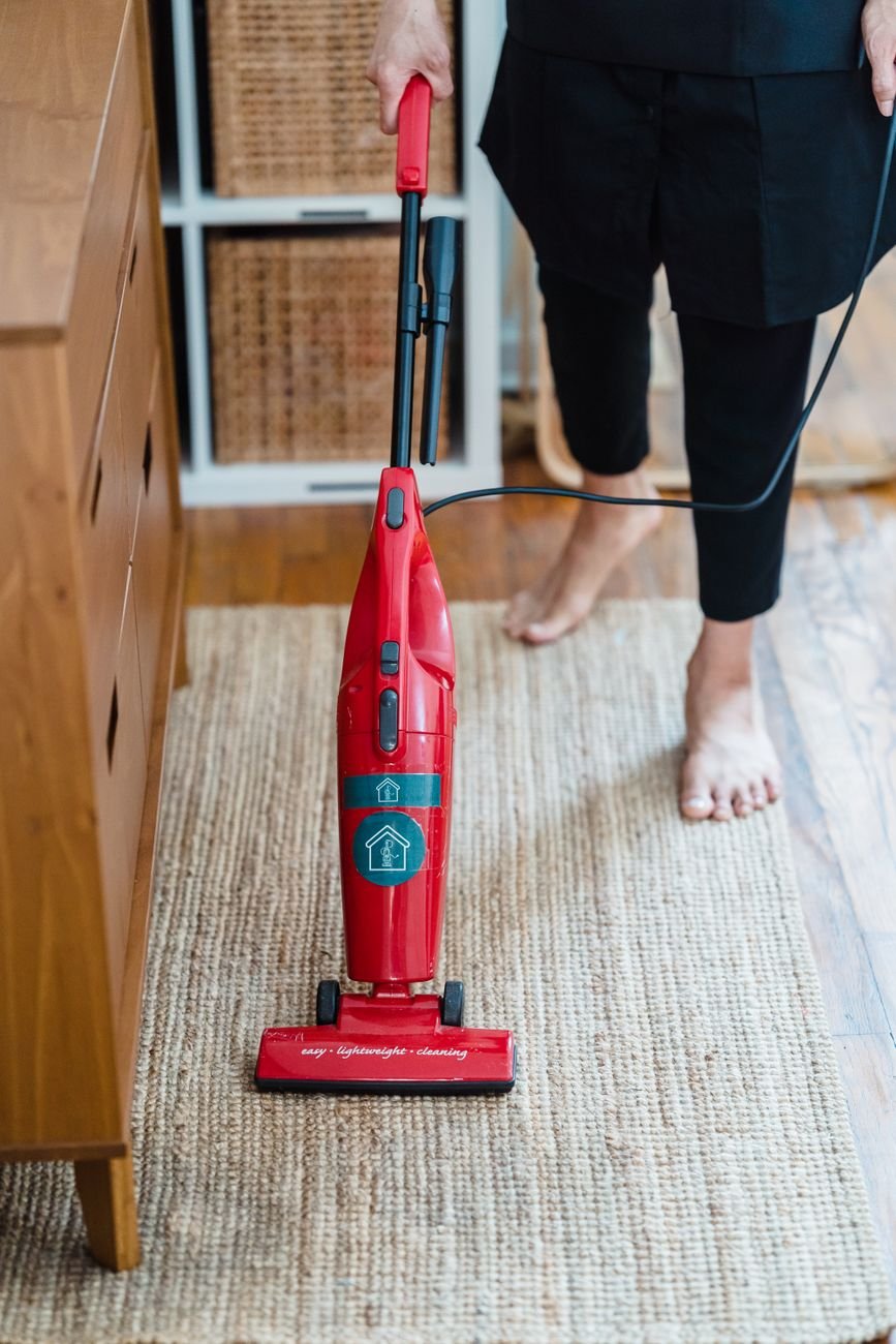 A person vacuuming a rug at home