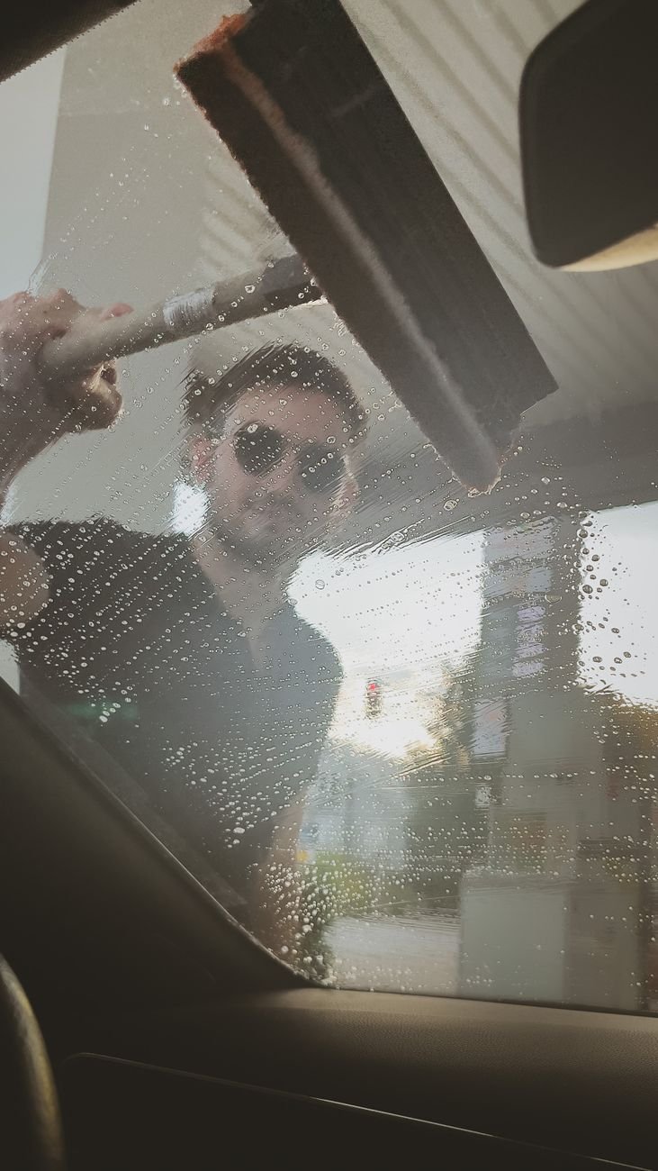 A squeegee being pulled across wet window glass